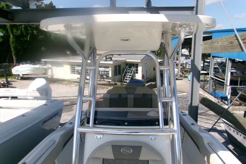 Slide: The Image of 2027 Key West 219 FS boat with T-top and console, docked at a marina. - 12