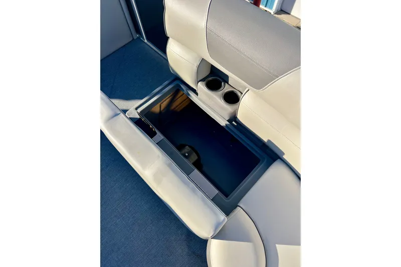Slide: The Image of 2021 Starcraft EX 20 C boat interior with storage compartment and cup holders. - 40