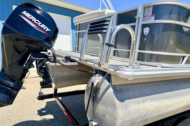 Slide: The Image of 2021 Starcraft EX 20 C pontoon boat with Mercury outboard motor, parked outdoors. - 16