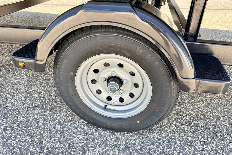Slide: The Image of 2021 Starcraft EX 20 C trailer wheel on asphalt surface. - 24