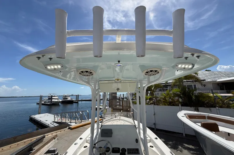 Slide: The Image of 2013 Sportsman Masters 227 Bay Boat with T-top, docked near marina under clear blue sky. - 19