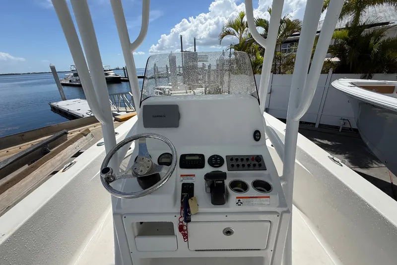 Slide: The Image of 2013 Sportsman Masters 227 Bay Boat console with steering wheel and controls, docked by the water. - 26