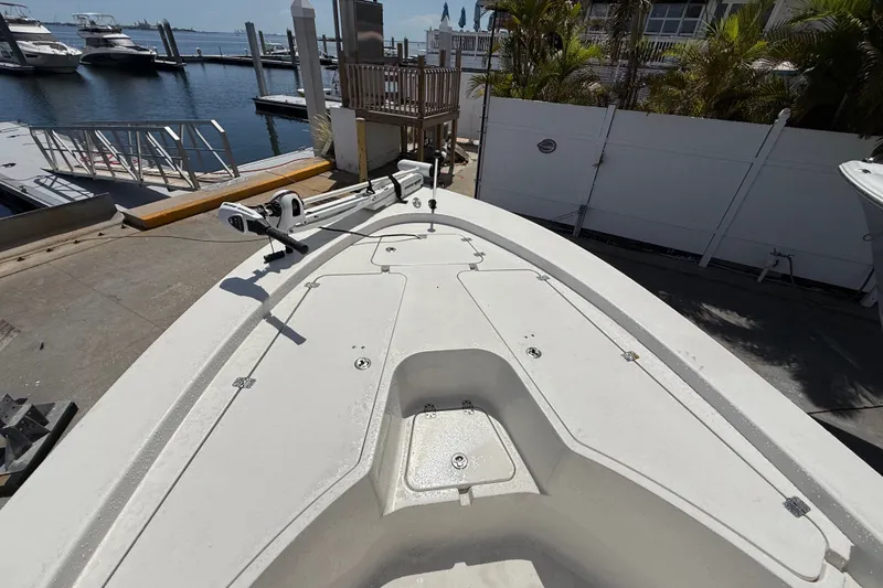 Slide: The Image of 2013 Sportsman Masters 227 Bay Boat docked at marina, showcasing spacious deck layout. - 16