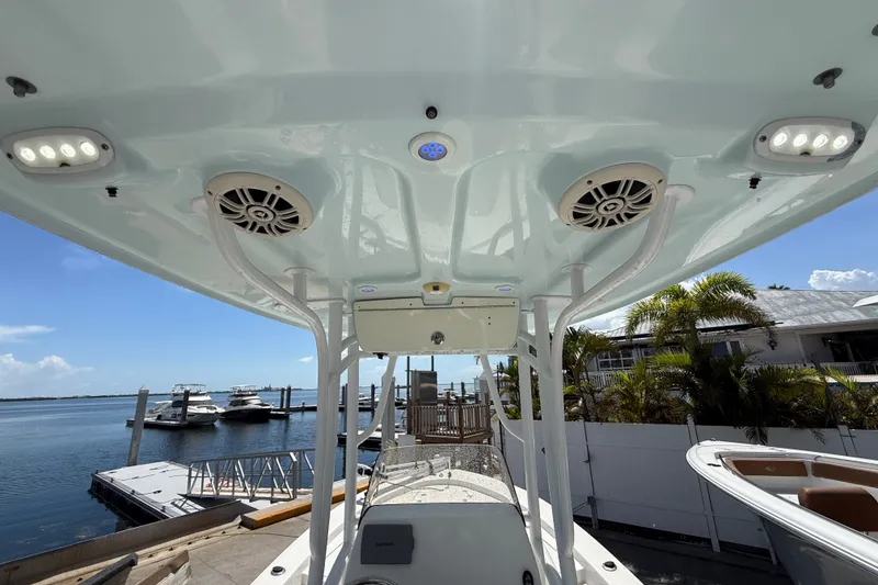 Slide: The Image of 2013 Sportsman Masters 227 Bay Boat interior with speakers and lights, docked by the marina. - 18