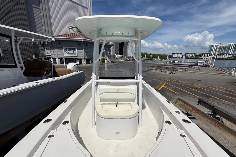 Slide: The Image of 2013 Sportsman Masters 227 Bay Boat docked at marina, showcasing spacious deck and seating. - 9