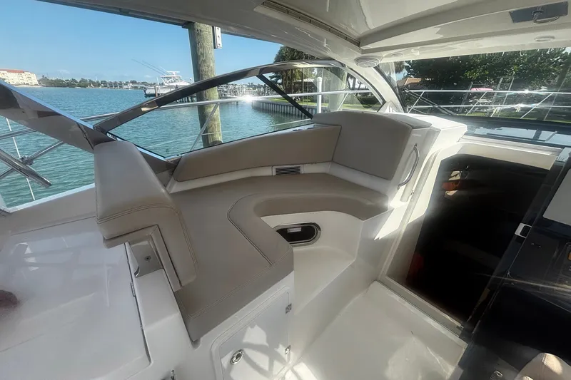 Slide: The Image of Interior of 2015 Pursuit SC 365i Sport Coupe with beige seating and waterfront view. - 18