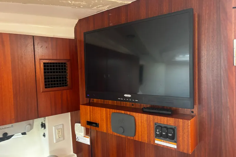 Slide: The Image of Flat-screen TV in 2015 Pursuit SC 365i Sport Coupe interior with wood paneling. - 11