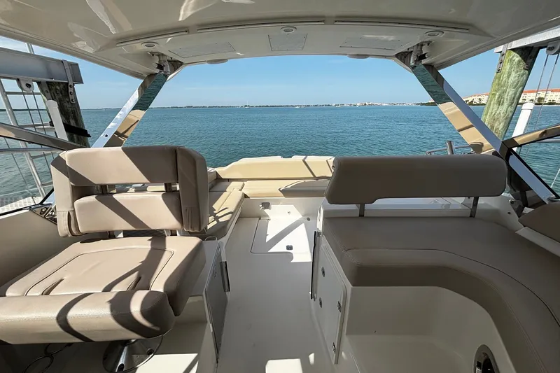 Slide: The Image of 2015 Pursuit SC 365i Sport Coupe interior with ocean view, featuring beige seating. - 23