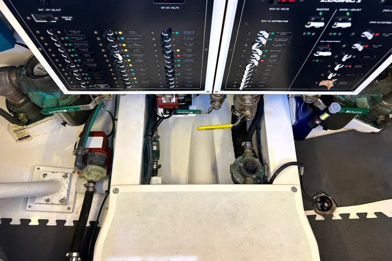 Slide: The Image of Electrical control panels and plumbing in a 2007 Legacy 32 boat engine room. - 33