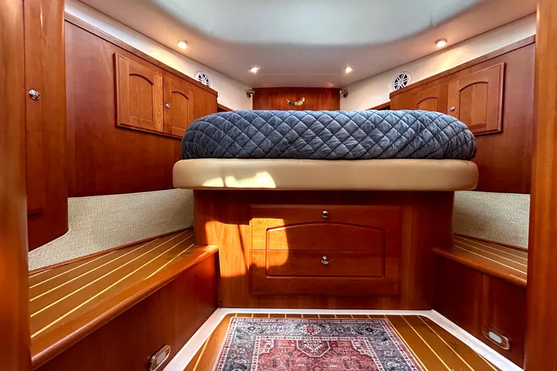 Slide: The Image of Luxurious 2007 Legacy 32 yacht cabin with wood finish and cozy bedding. - 20
