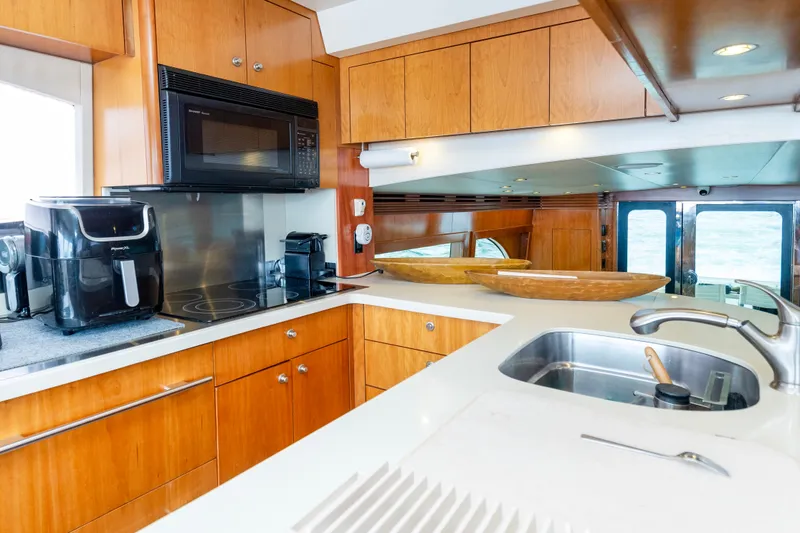 Slide: The Image of Luxurious kitchen interior of 2008 Hatteras 64 Motor Yacht with modern appliances and wood cabinetry. - 9