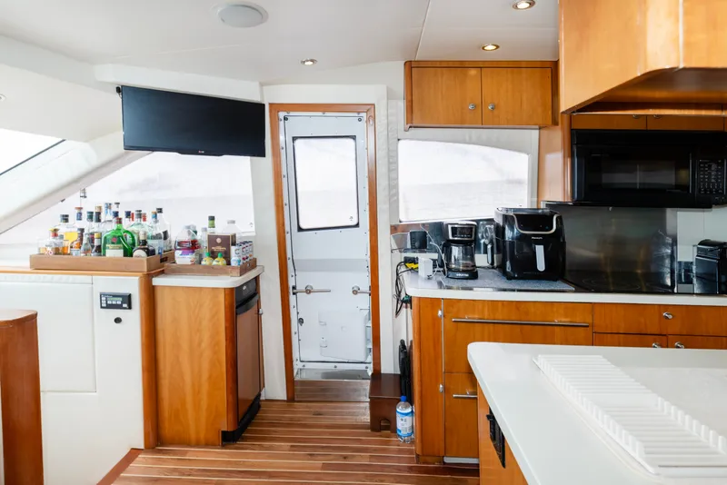 Slide: The Image of Interior of 2008 Hatteras 64 Motor Yacht kitchen with appliances and bar setup. - 7