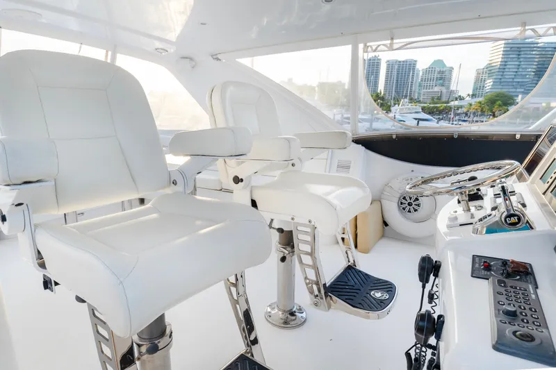 Slide: The Image of Luxurious helm of 2008 Hatteras 64 Motor Yacht with white captain chairs and control panel. - 17