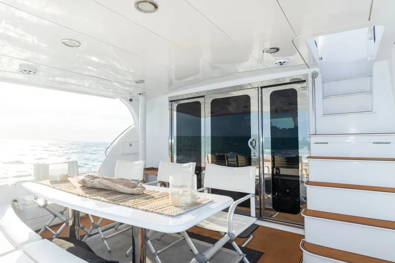 Slide: The Image of Luxurious 2008 Hatteras 64 Motor Yacht deck with elegant dining area and ocean view. - 14