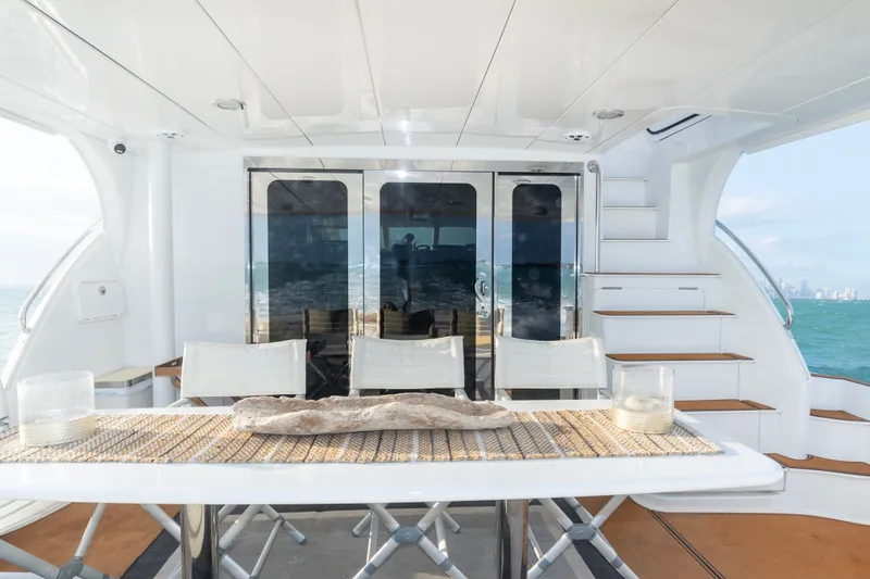 Slide: The Image of Luxurious 2008 Hatteras 64 Motor Yacht deck with elegant dining setup. - 15