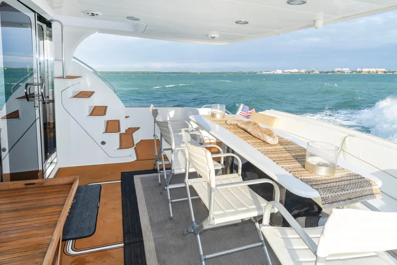 Slide: The Image of Luxurious 2008 Hatteras 64 Motor Yacht deck with ocean view and elegant seating area. - 13