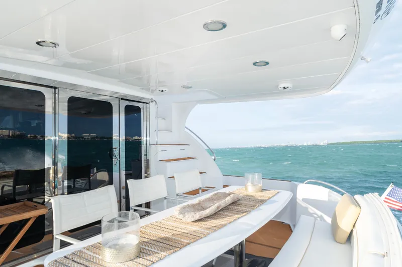 Slide: The Image of Luxurious 2008 Hatteras 64 Motor Yacht deck with ocean view and elegant seating area. - 12