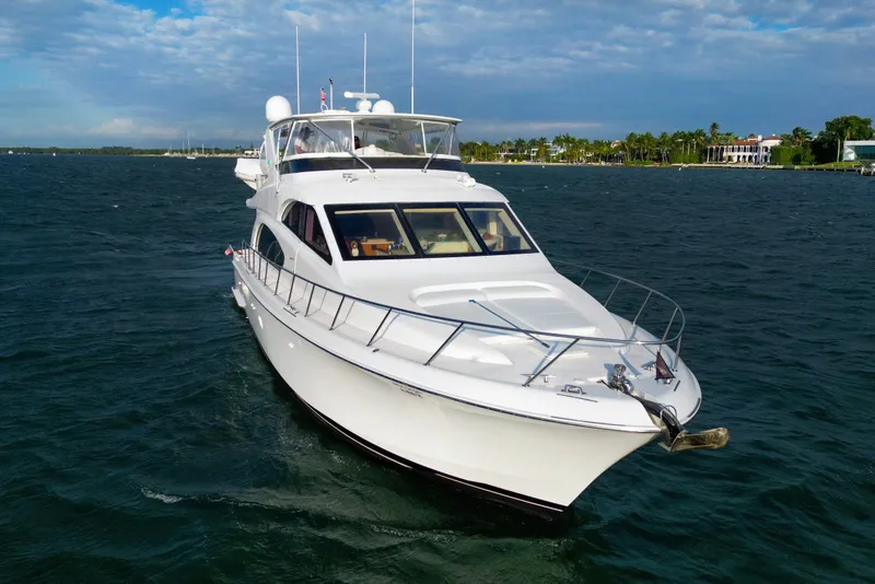 The Image of 2008 Hatteras 64 Motor Yacht cruising on open water under a clear sky. - 0