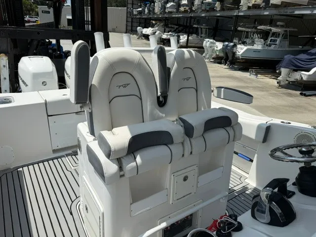 Slide: The Image of Two cushioned captain's chairs on a boat with gray accents and a helm console. - 14