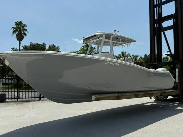 Slide: The Image of A gray 2018 Tidewater 280 CC Adventure boat is being lifted by a crane. - 2