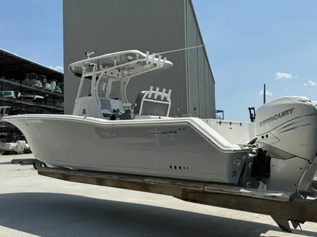 Slide: The Image of 2018 Tidewater 280 CC Adventure on a trailer, featuring twin Mercury engines, in front of a warehouse. - 1