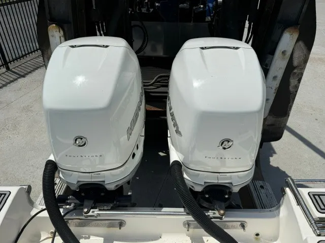 Slide: The Image of Two white Mercury outboard engines on a boat, parked at a dock. - 23