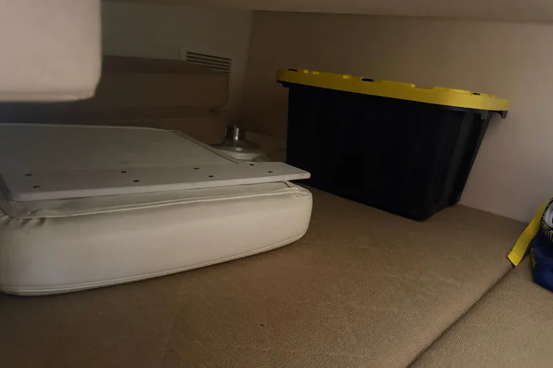 Slide: The Image of Interior storage area of a 2005 Sea Ray Sundancer 260 boat with cushions and a storage bin. - 29