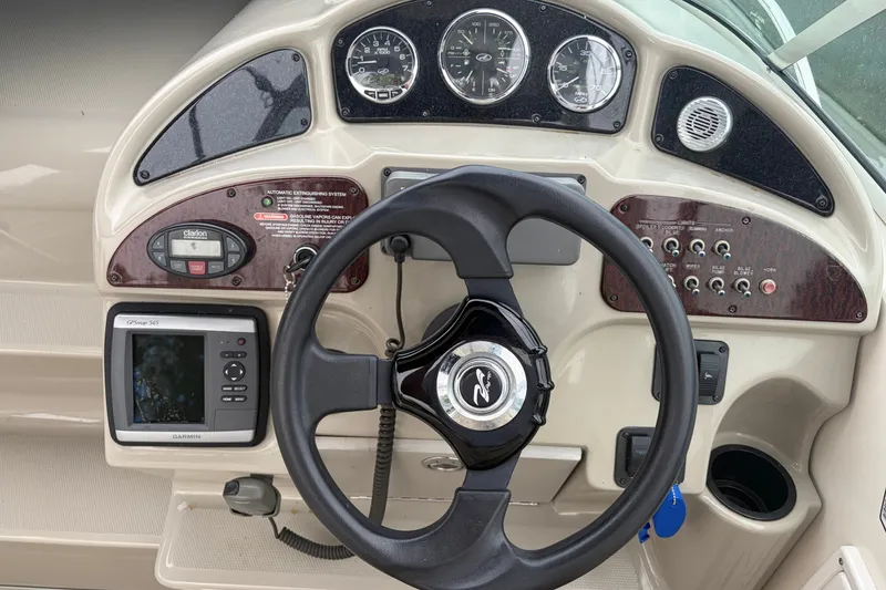 Slide: The Image of Dashboard of a 2005 Sea Ray Sundancer 260 boat with steering wheel and controls. - 13