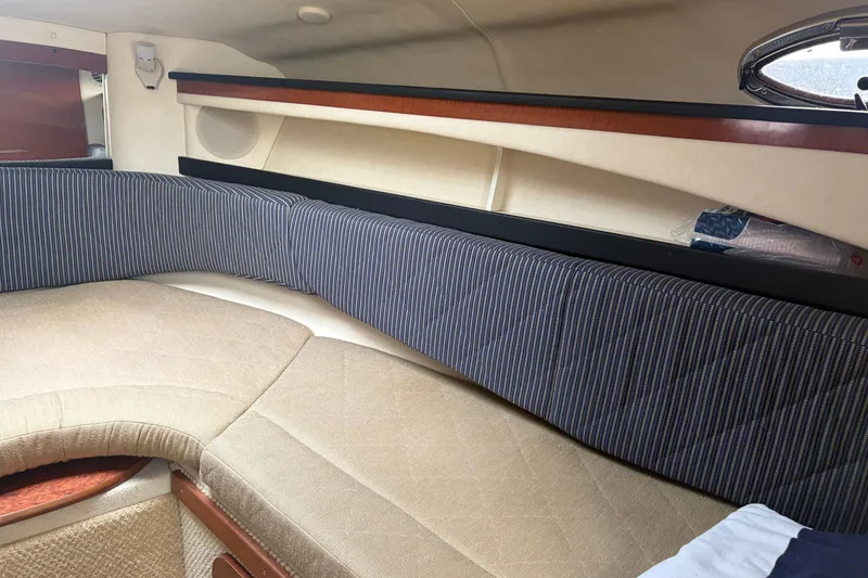 Slide: The Image of Interior cabin of 2005 Sea Ray Sundancer 260 with striped cushions and beige seating. - 21