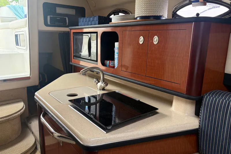 Slide: The Image of Interior of 2005 Sea Ray Sundancer 260 boat with kitchenette and wooden cabinetry. - 24