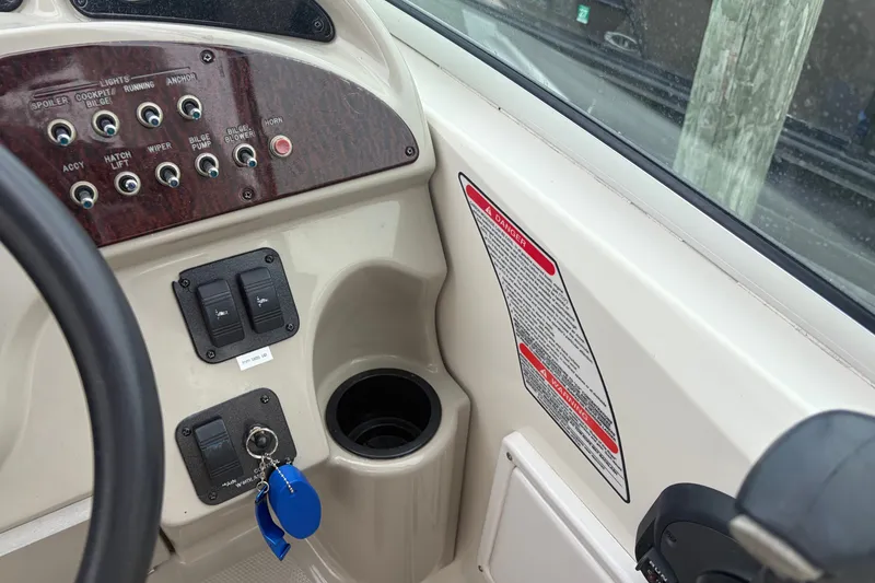 Slide: The Image of Control panel of a 2005 Sea Ray Sundancer 260 boat with switches and warning labels. - 16