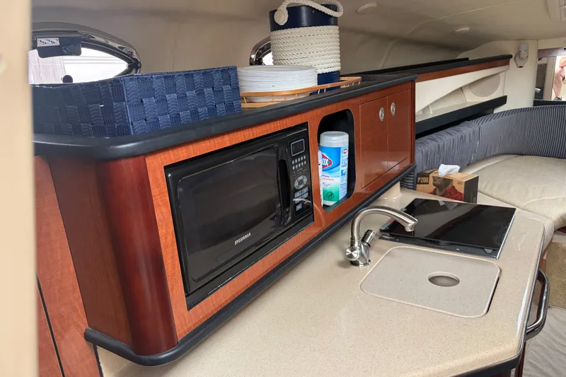 Slide: The Image of Interior of 2005 Sea Ray Sundancer 260 with kitchenette, microwave, and sink. - 23