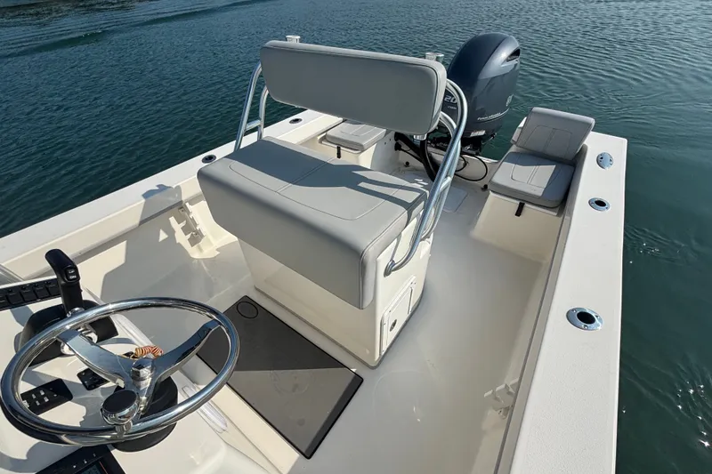Slide: The Image of 2023 May-Craft 2300 CCX boat interior with steering wheel and seating on water. - 7