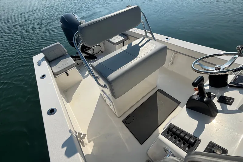 Slide: The Image of 2023 May-Craft 2300 CCX boat interior with helm, seating, and controls on water. - 15