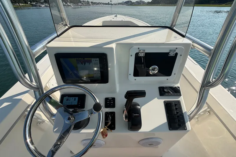 Slide: The Image of 2023 May-Craft 2300 CCX boat console with steering wheel and navigation display. - 9