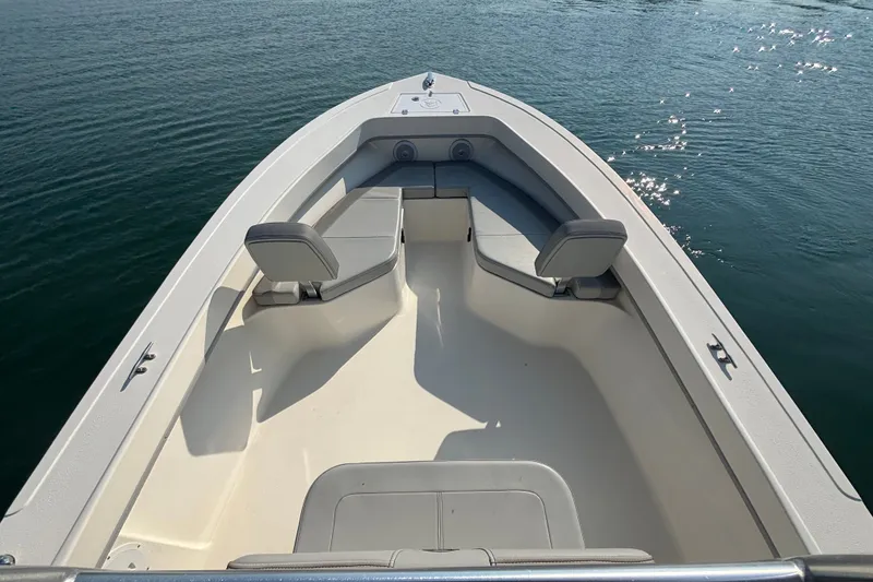 Slide: The Image of 2023 May-Craft 2300 CCX boat interior with seating, on calm water. - 5
