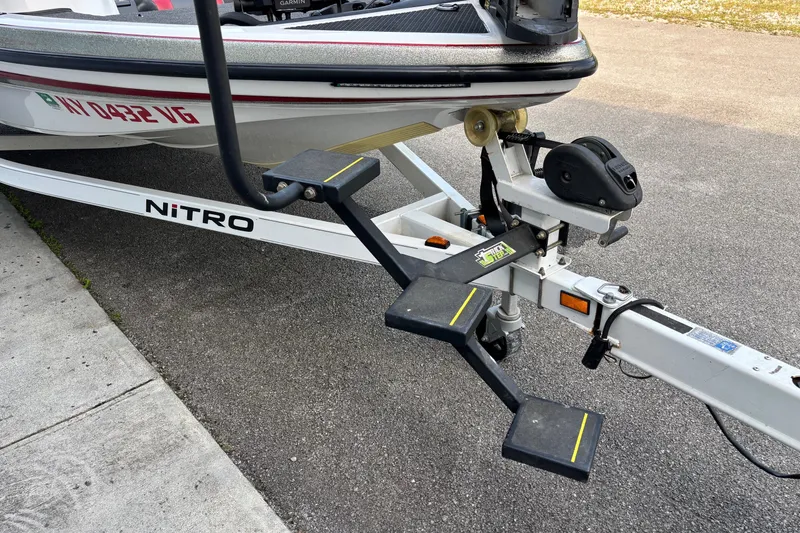Slide: The Image of 2004 Nitro NX 882 SC boat trailer with steps and winch on pavement. - 3