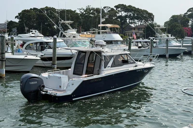 Slide: The Image of 2024 Cutwater C-248 Coupe boat docked in a marina with other vessels. - 7