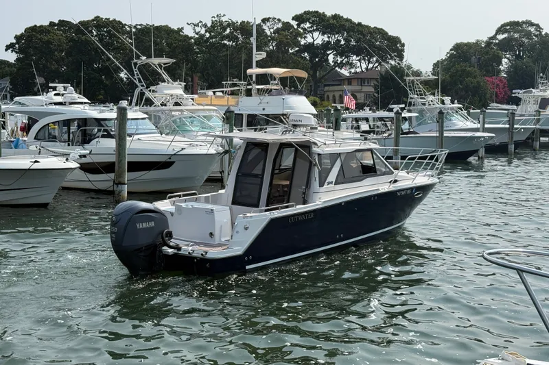Slide: The Image of 2024 Cutwater C-248 Coupe boat docked in a marina with other vessels. - 8