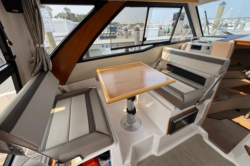 Slide: The Image of Interior of 2024 Cutwater C-248 Coupe, featuring seating and a wooden table. - 24