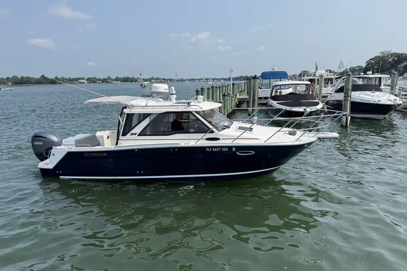 Slide: The Image of 2024 Cutwater C-248 Coupe boat docked in a marina, featuring sleek design and Yamaha engine. - 5