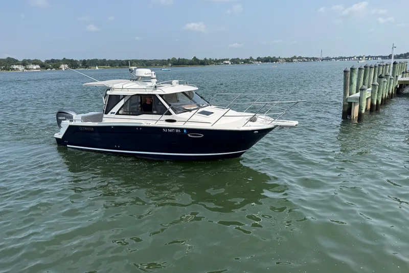 Slide: The Image of 2024 Cutwater C-248 Coupe boat cruising near a dock on a sunny day. - 4