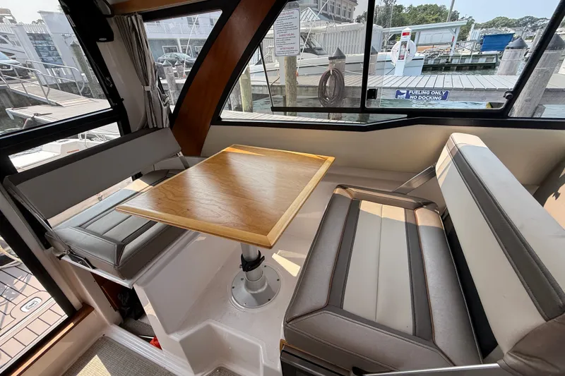 Slide: The Image of Interior of 2024 Cutwater C-248 Coupe featuring a cozy dining area with a wooden table. - 23