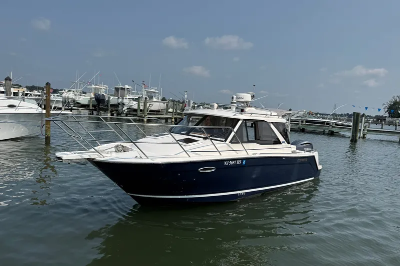 Slide: The Image of 2024 Cutwater C-248 Coupe boat docked in a marina under a clear sky. - 11