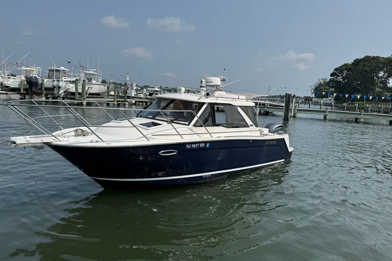 Slide: The Image of 2024 Cutwater C-248 Coupe boat docked in a marina under clear skies. - 12