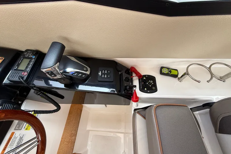 Slide: The Image of 2024 Cutwater C-248 Coupe helm with controls, radio, and cup holders. - 22