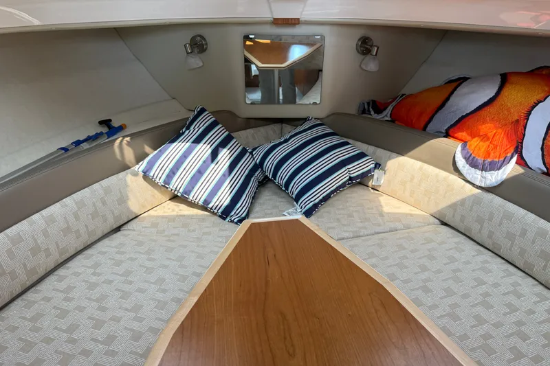 Slide: The Image of 2024 Cutwater C-248 Coupe cabin interior with striped pillows and cozy seating. - 18
