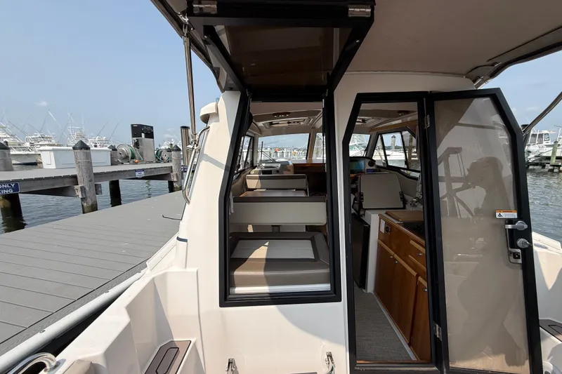 Slide: The Image of 2024 Cutwater C-248 Coupe interior view, docked at marina with visible seating and helm. - 34