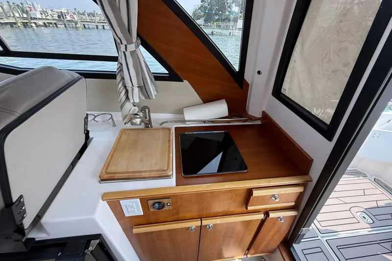 Slide: The Image of 2024 Cutwater C-248 Coupe interior with kitchenette, featuring cutting board and sink by a window. - 20