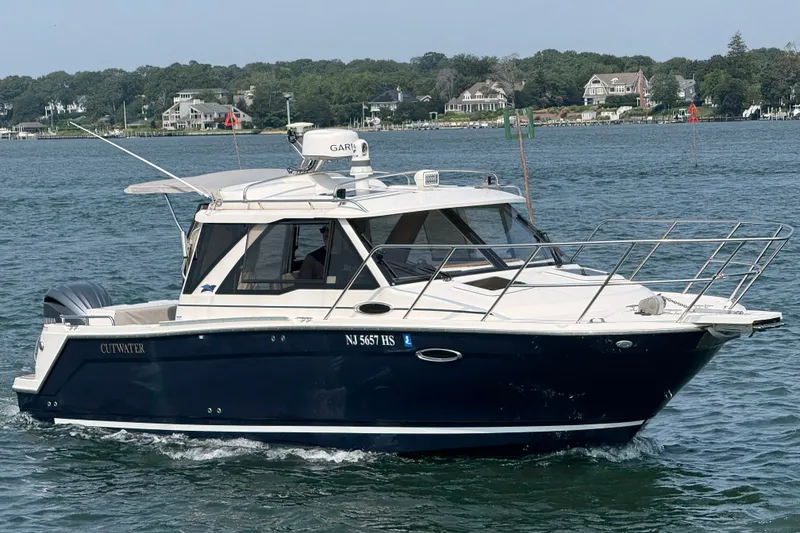 The Image of 2024 Cutwater C-248 Coupe cruising on a scenic lake with waterfront homes in the background. - 1